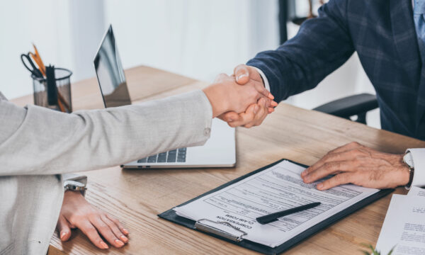 cropped view shaking hands businessman