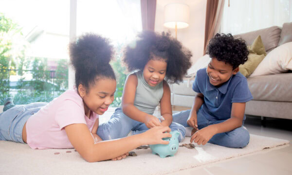 Happiness African family with children saving money in piggy bank for planning future of expense for financial success, deposit and investment, domestic life, business and finance concept.